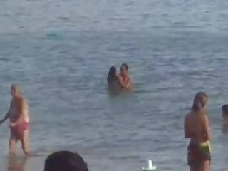 Casal trepando na praia.